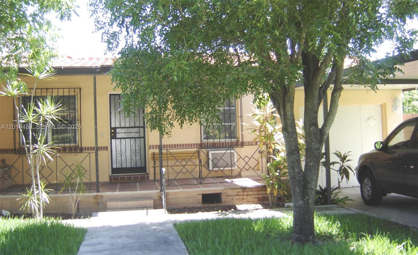 A single-story house with a tiled porch, metal security bars, and a carport — 224 NE 47th St, Miami FL 33137, MIAMI, FL