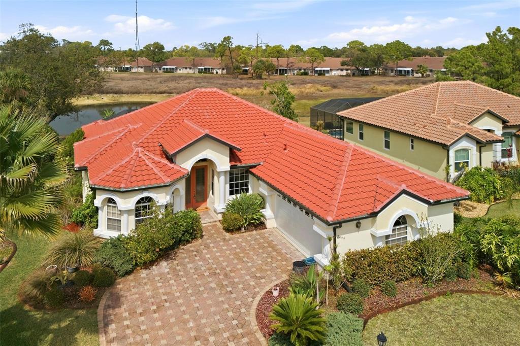 An aerial view shows a house with a red tile roof and a paved driveway — 2499 SILVER PALM ROAD, NORTH PORT, FL