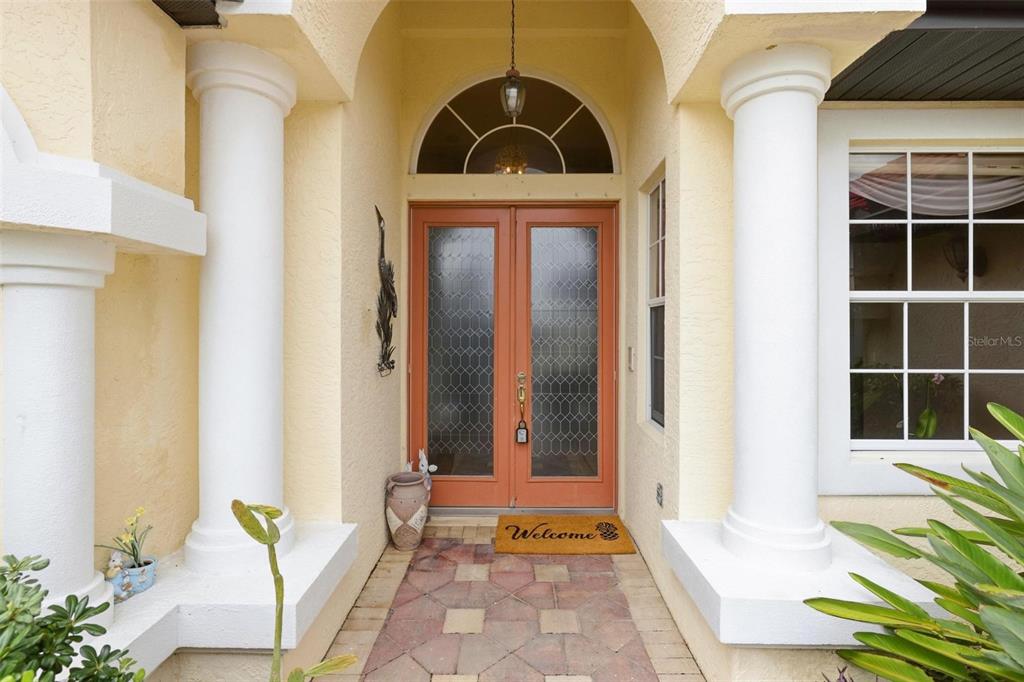 A front entryway features double glass doors, white columns, and a paved walkway — 2499 SILVER PALM ROAD, NORTH PORT, FL