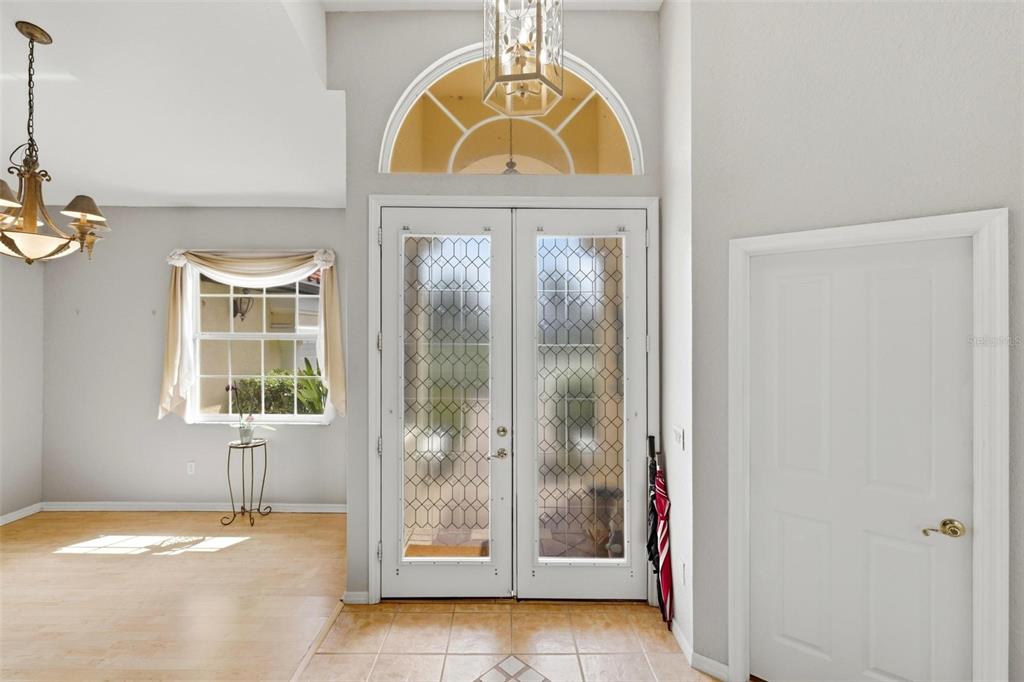 An entryway features a double glass door with a transom window, tile flooring, and a chandelier — 2499 SILVER PALM ROAD, NORTH PORT, FL