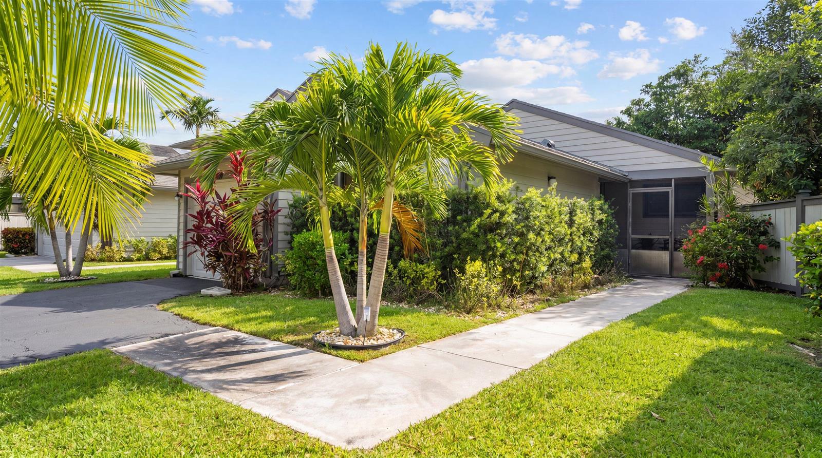 A single-story house with a palm tree in the front yard and a screened entryway — 2482 Bedford Mews Drive, Wellington FL 33414, WELLINGTON, FL