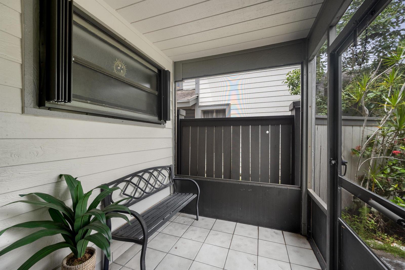 A screened-in porch features white tile flooring, a metal bench, and a privacy fence — 2482 Bedford Mews Drive, Wellington FL 33414, WELLINGTON, FL