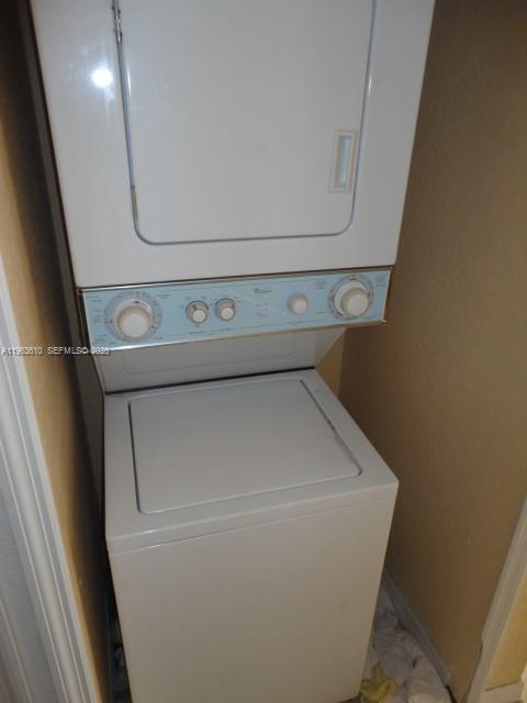 A white stacked washer and dryer unit is installed in a small closet — 875 SW 6th Pl, Florida City FL 33034, FLORIDA CITY, FL