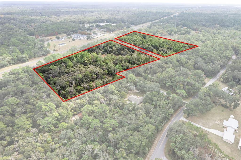 An aerial view shows two wooded plots of land outlined in red near a road — 11570 W GARNET COURT, CRYSTAL RIVER, FL