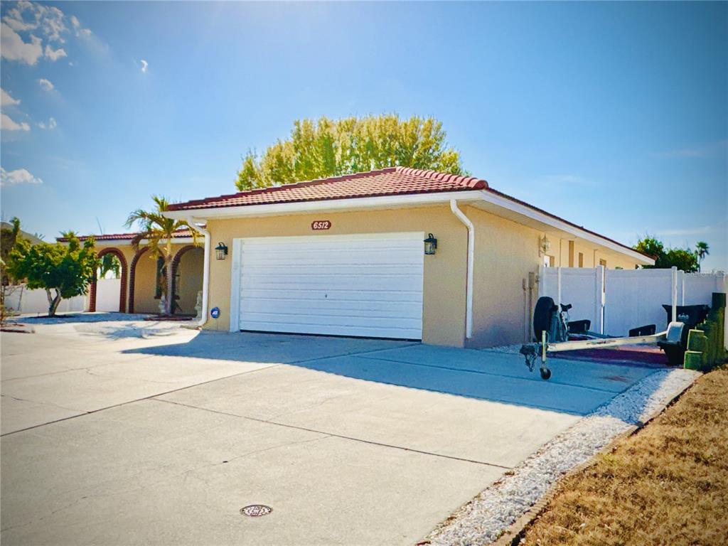 A tan house with a white garage door and a red tile roof — 6512 MANILA PALM WAY, APOLLO BEACH, FL