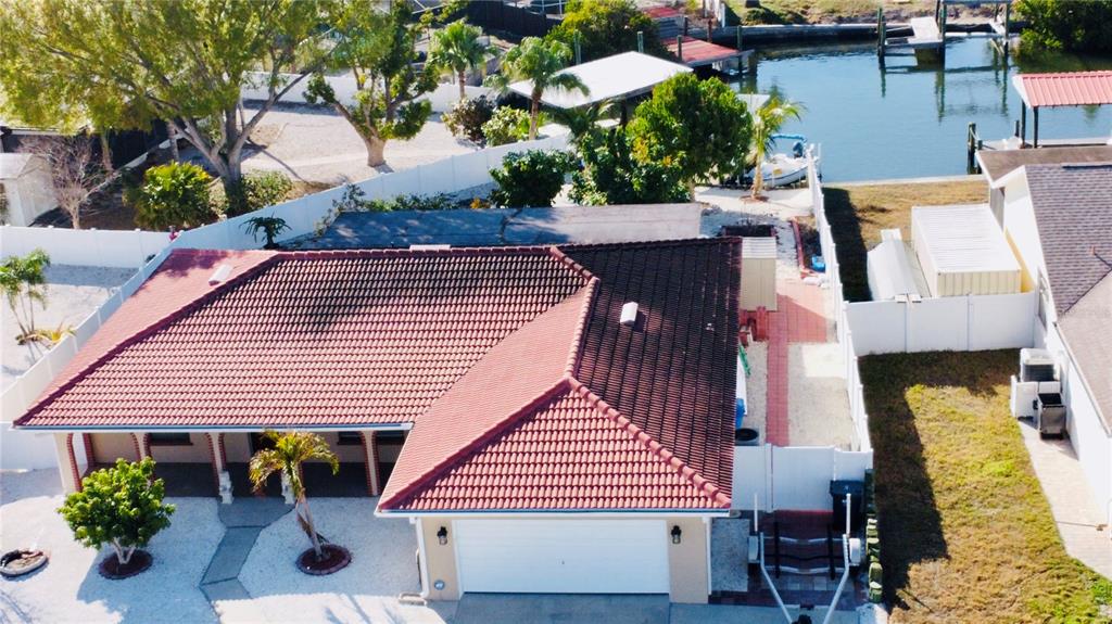 An aerial view shows a house with a red tile roof and a canal-side backyard — 6512 MANILA PALM WAY, APOLLO BEACH, FL