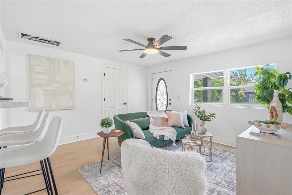 A kitchen with white cabinets and a breakfast bar featuring three stools — 2110 E NEDRO ROAD, TAMPA, FL