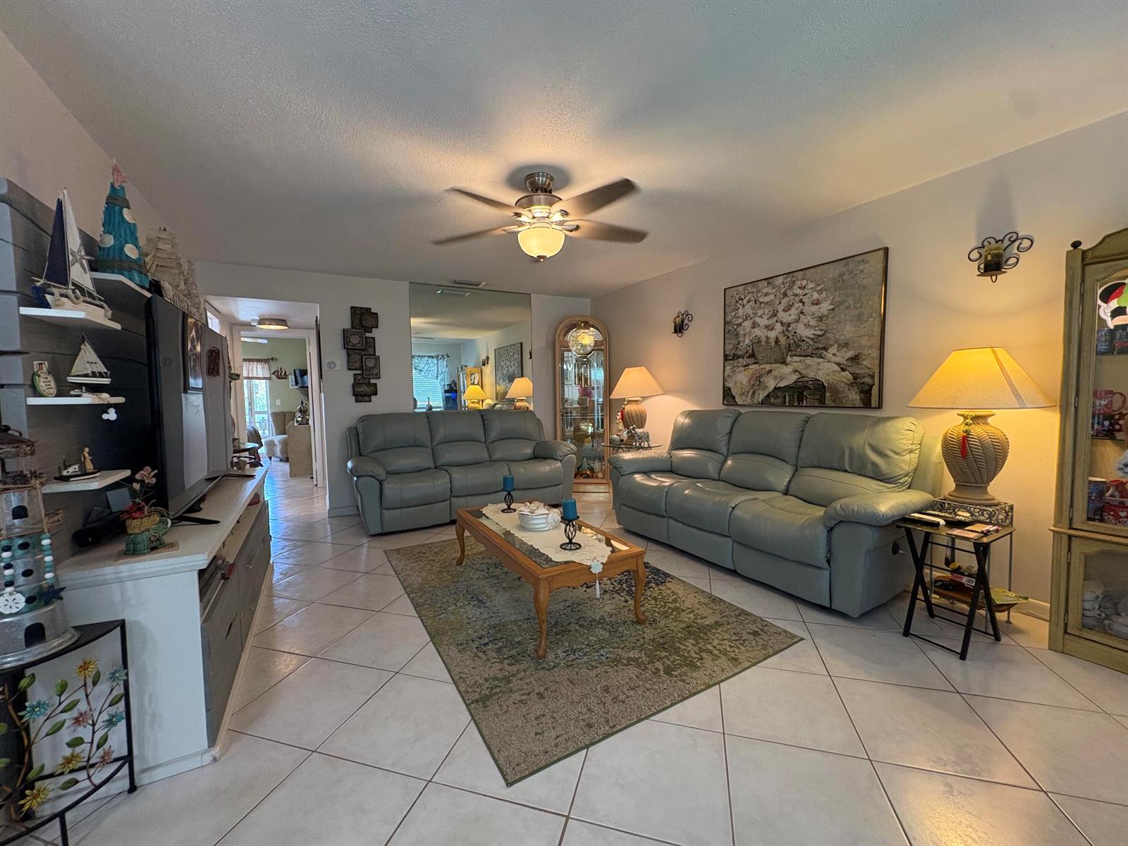 A living room features light-colored tile floors, two leather sofas, and a central ceiling fan — 175 Bedford # G, West Palm Beach FL 33417, WEST PALM BEACH, FL