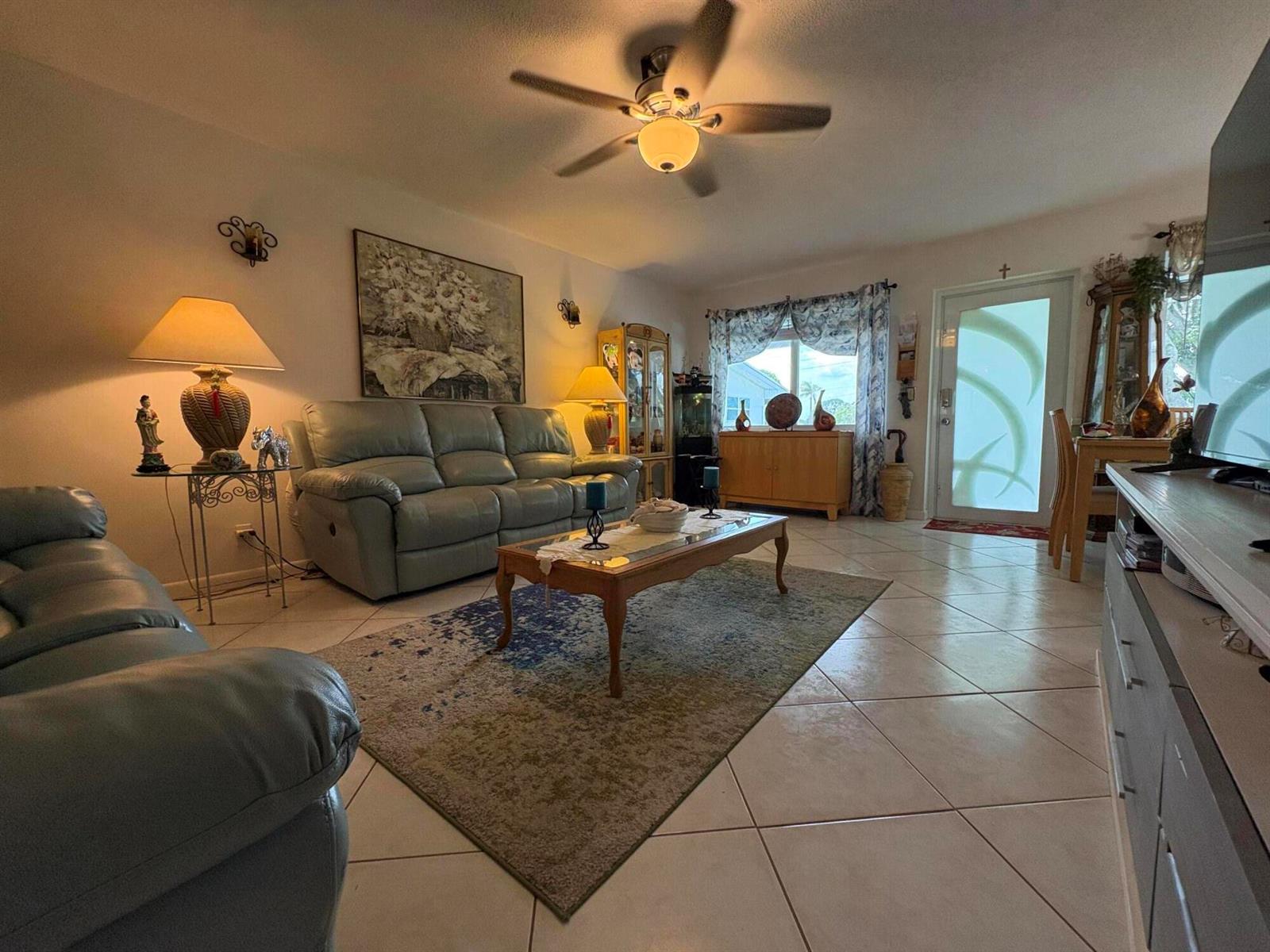 A living room with tile floors, a ceiling fan, leather sofas, and a coffee table — 175 Bedford # G, West Palm Beach FL 33417, WEST PALM BEACH, FL