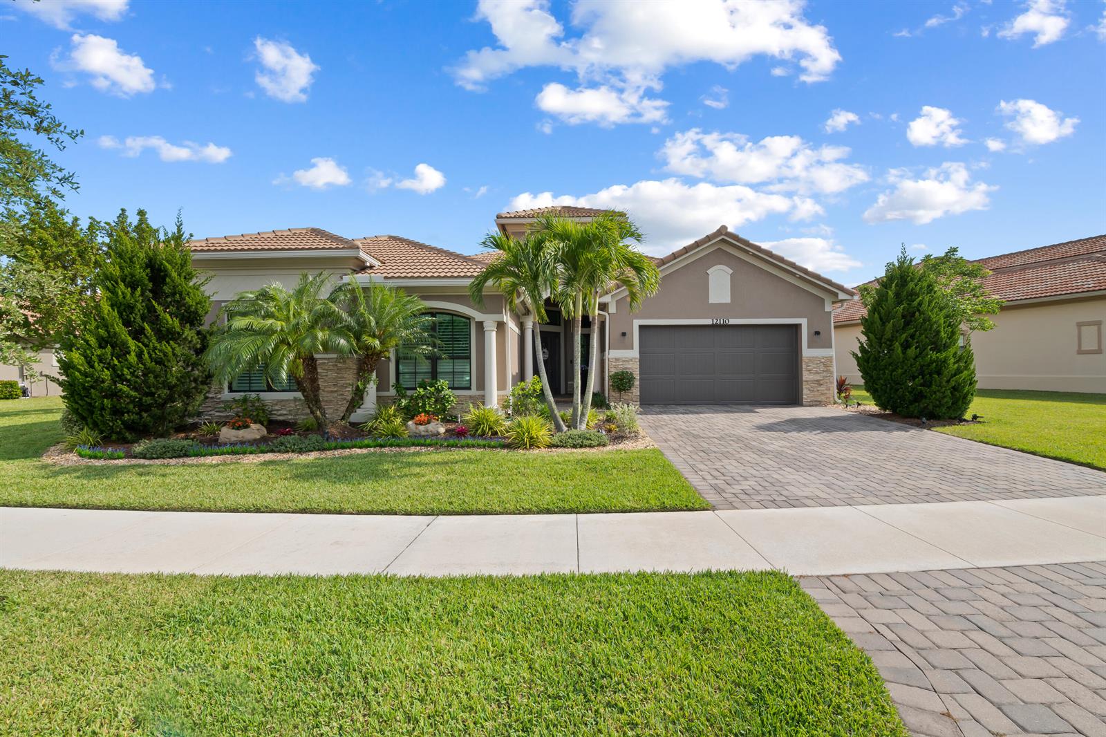A single-story house with a tiled roof, a two-car garage, and palm trees in front — 12110 Bastille Circle E, Parkland FL 33076, PARKLAND, FL