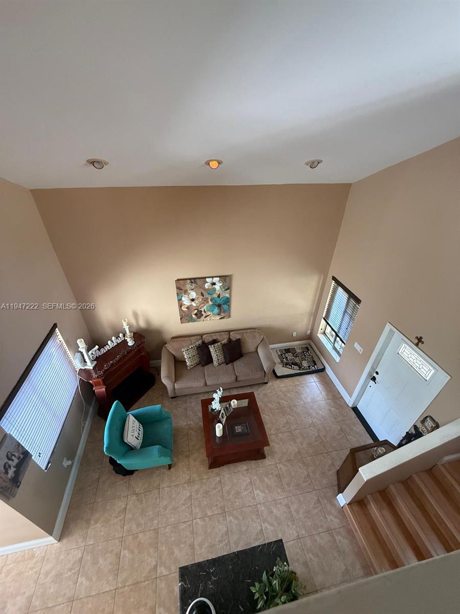 A high-angle view of a living room with tile floors, a sofa, and a teal chair — 14534 SW 144th Ter, Miami FL 33186, MIAMI, FL