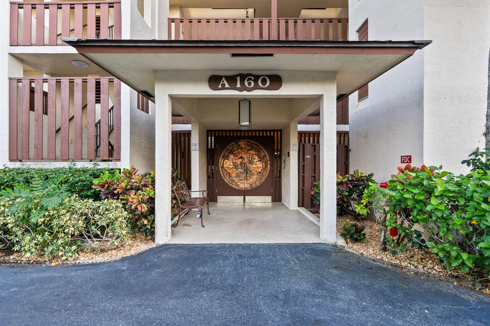 A covered entryway leads to a building entrance featuring a decorative circular door panel — 160 SE Saint Lucie Boulevard # 402a, Stuart FL 34996, STUART, FL