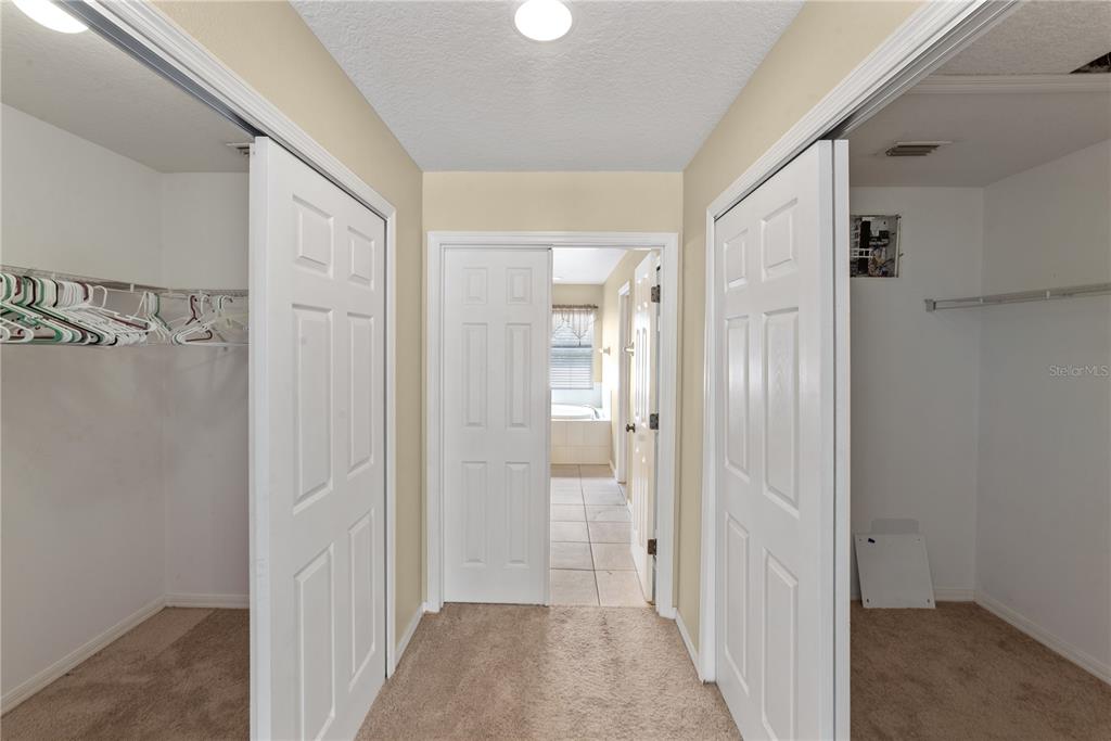 A hallway features carpeted flooring, two white closet doors, and a doorway leading to a bathroom — 6110 39TH COURT E, BRADENTON, FL