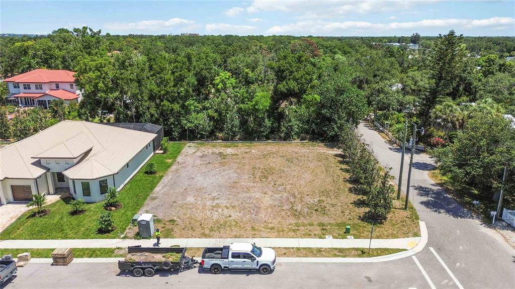 An aerial view shows a vacant, rectangular residential lot situated between a house and road — 3820 PARROT BAY COURT, OSPREY, FL