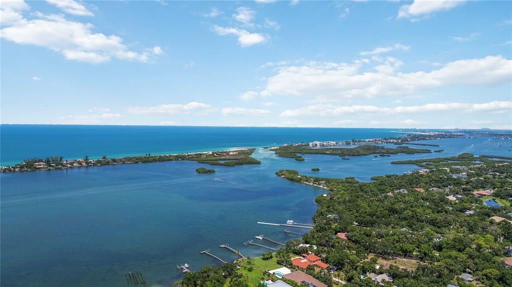 An aerial view shows a coastal landscape with a bay, mangroves, and residential properties — 3820 PARROT BAY COURT, OSPREY, FL