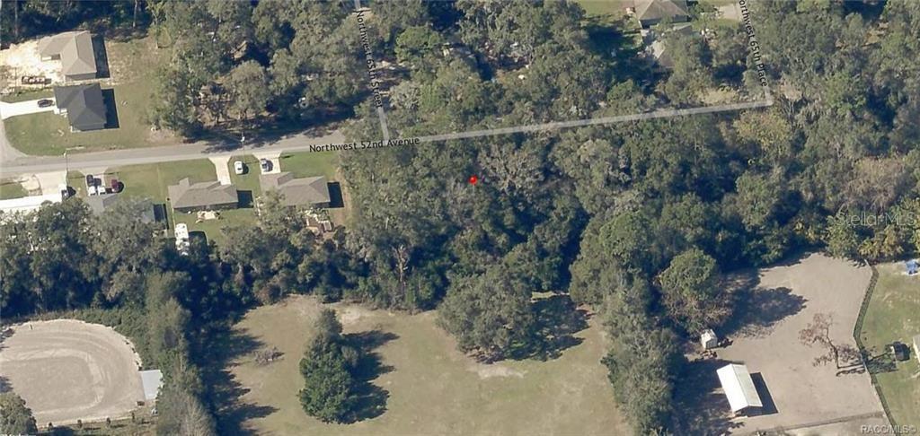 This aerial view shows a wooded lot located near a residential street and open fields — 00 NW 52ND AVENUE Lot 6, OCALA, FL