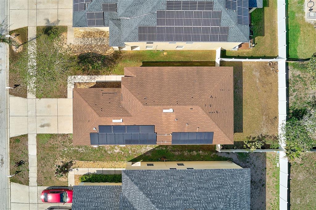 An aerial view shows a house with brown shingles and solar panels on the roof — 12136 TREE HAVEN AVENUE, GIBSONTON, FL