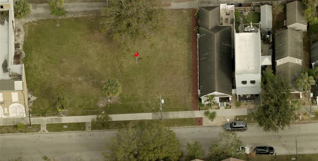 An aerial view shows a vacant grassy lot next to a multi-story residential building — 2133 W SPRUCE STREET, TAMPA, FL