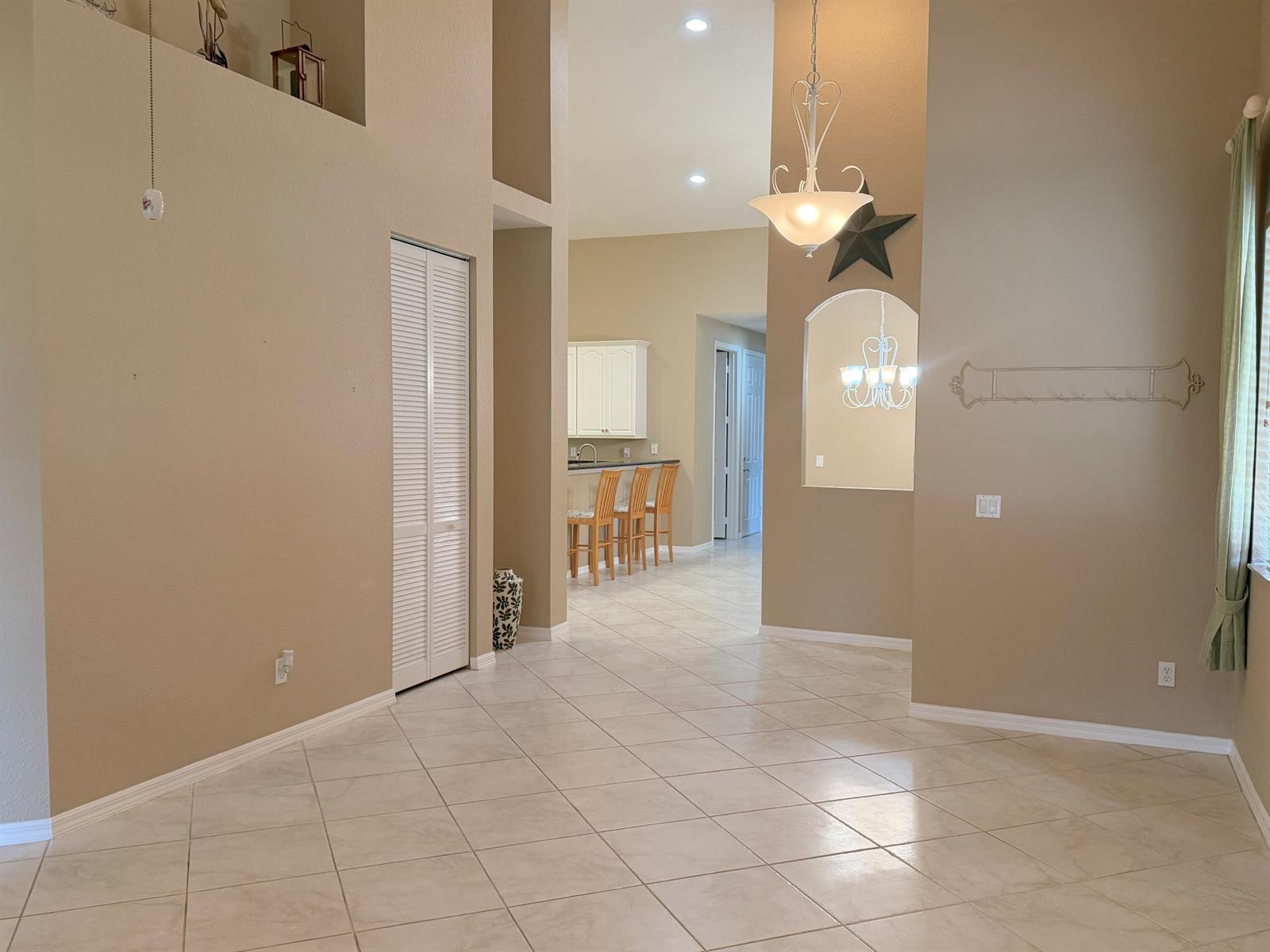 A tiled living area leads to a kitchen with bar seating and a recessed alcove — 6510 Oxford Circle # 101, Vero Beach FL 32966, VERO BEACH, FL