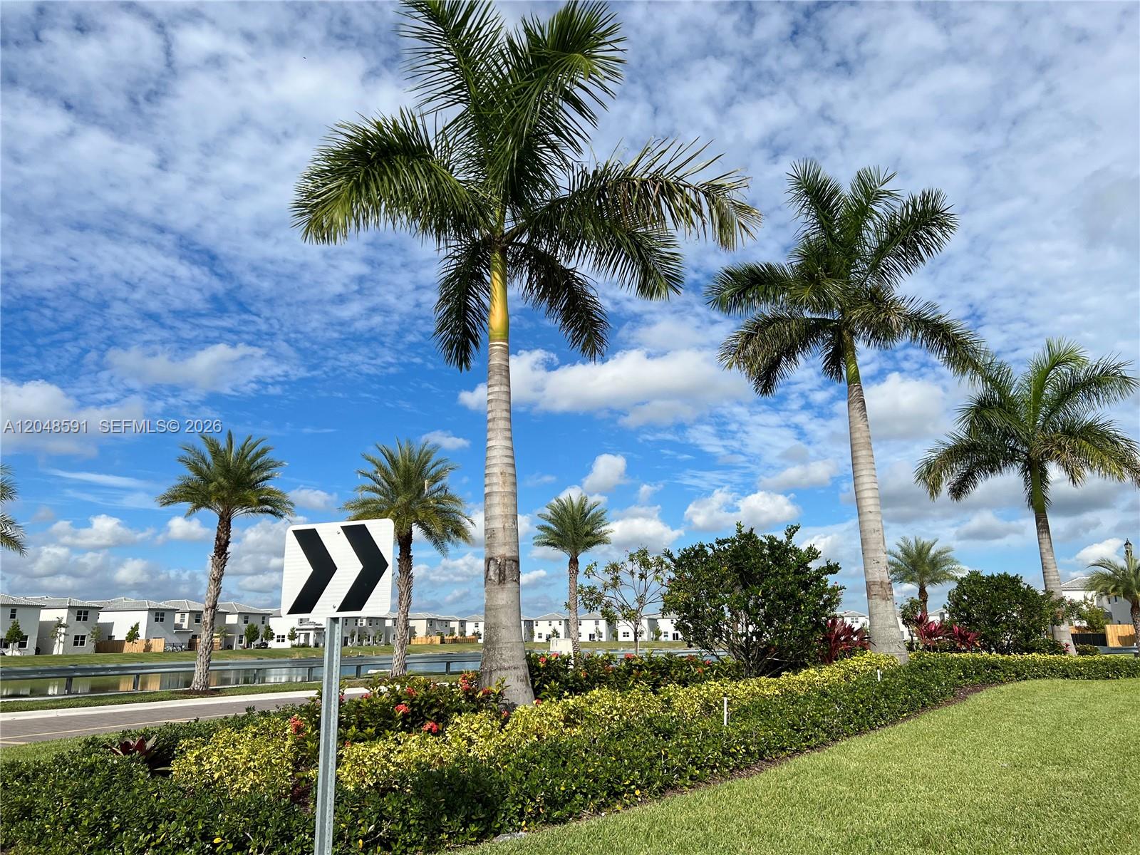 A road sign stands in front of palm trees and a pond near residential buildings — 1864 SE 27th Rd, Homestead FL 33035, HOMESTEAD, FL