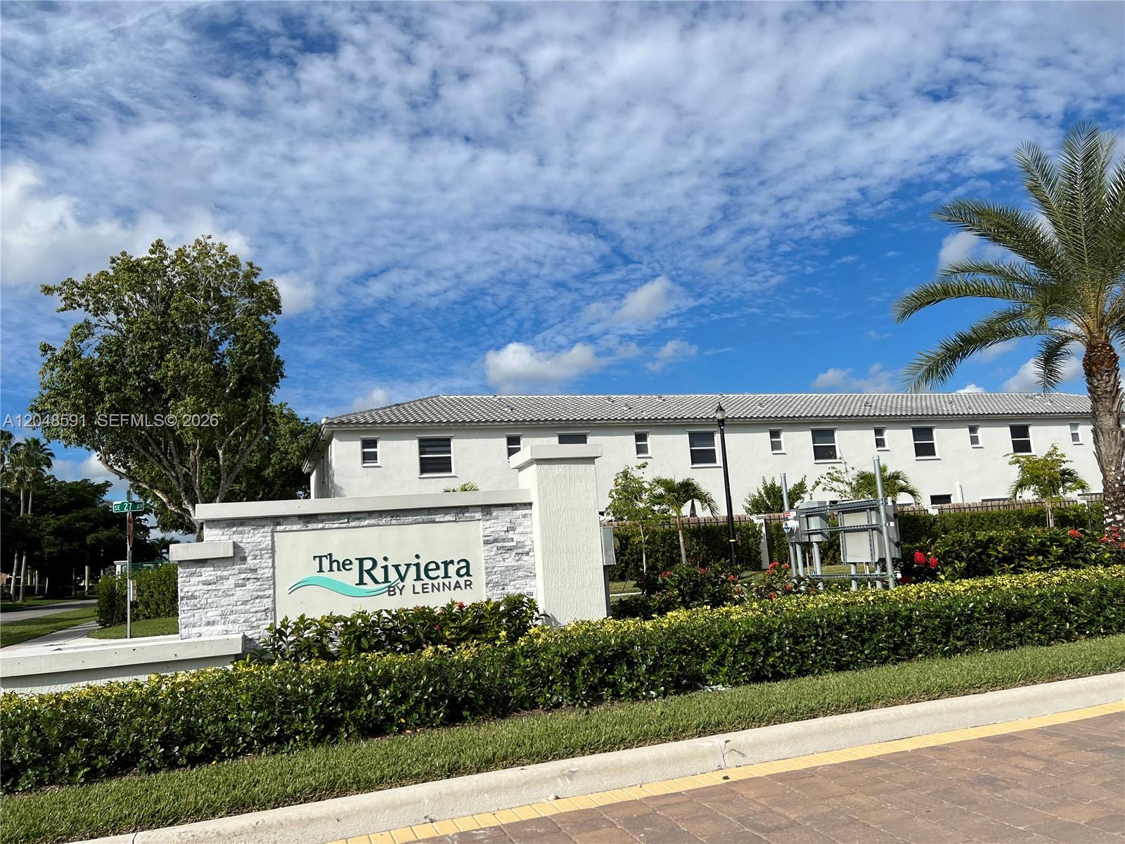 A stone monument sign for The Riviera by Lennar stands before a white residential building — 1864 SE 27th Rd, Homestead FL 33035, HOMESTEAD, FL