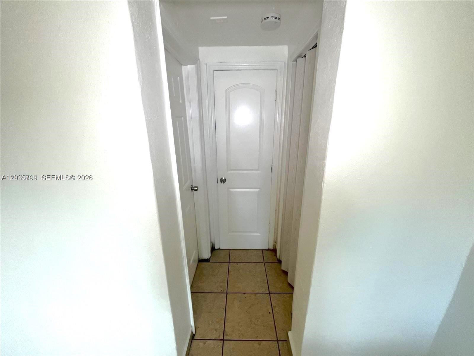 A narrow hallway features tiled flooring, white walls, and two closed interior doors — 420 NW 10th St # 7, Miami FL 33136, MIAMI, FL