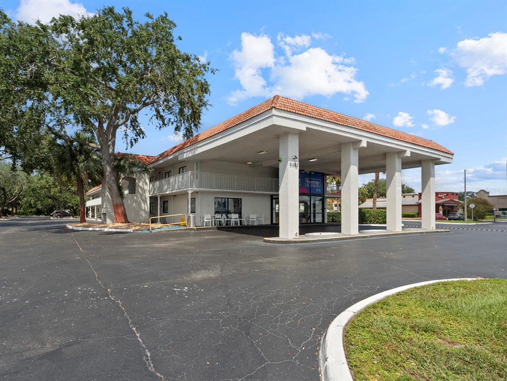 A multi-story hotel building features a large covered entrance with white pillars and parking — 5367 W IRLO BRONSON MEMORIAL HIGHWAY UNIT 1-117, KISSIMMEE, FL