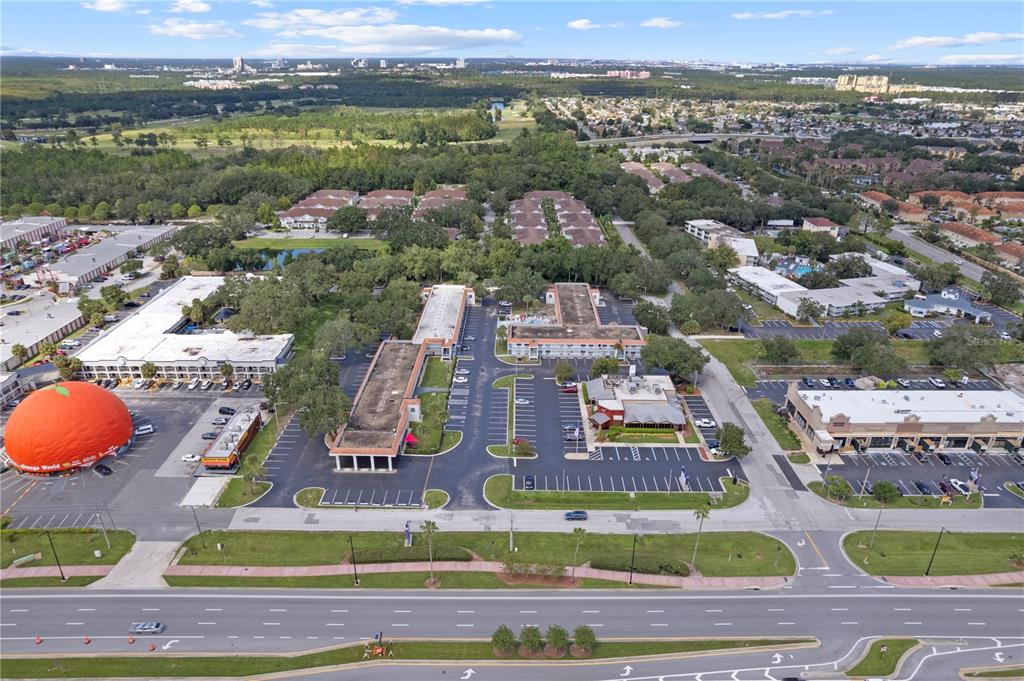 An aerial view shows a commercial property featuring a large orange-shaped structure and parking lots — 5367 W IRLO BRONSON MEMORIAL HIGHWAY UNIT 1-117, KISSIMMEE, FL