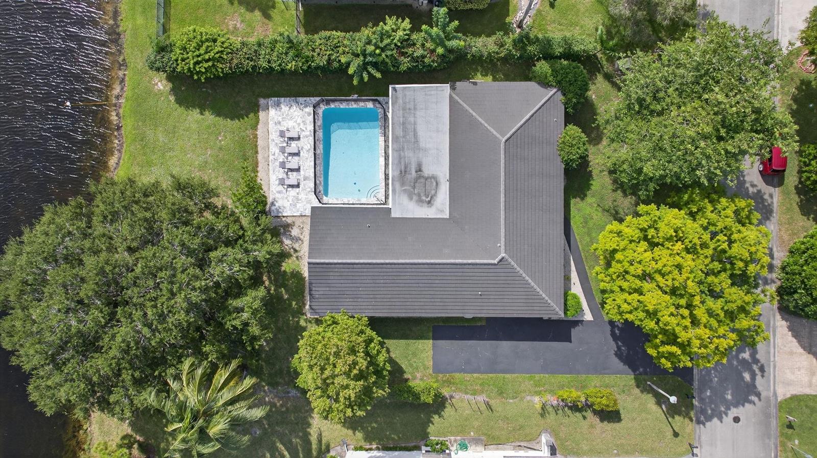 An aerial view shows a house with a dark roof, a pool, and a driveway — 2421 NW 114th Avenue, Coral Springs FL 33065, CORAL SPRINGS, FL