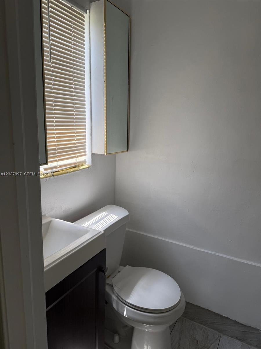 A small bathroom features a white toilet, a vanity with a sink, and a medicine cabinet — 1324 N 58 AVE # 1, Hollywood FL 33021, HOLLYWOOD, FL