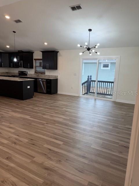 An open-concept kitchen and living area features dark cabinetry, a kitchen island, and sliding doors — 902 W ALSOBROOK STREET, PLANT CITY, FL