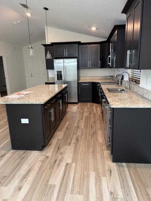 A kitchen features dark cabinetry, granite countertops, a center island, and light wood-look flooring — 902 W ALSOBROOK STREET, PLANT CITY, FL