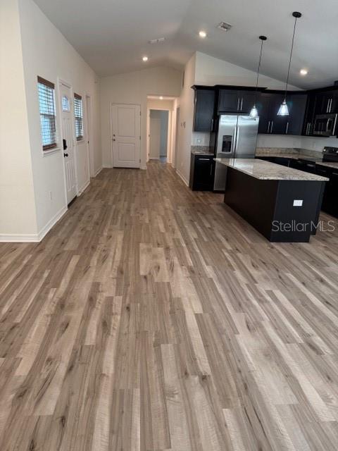 A kitchen with dark cabinets and a granite island opens into a living area — 902 W ALSOBROOK STREET, PLANT CITY, FL