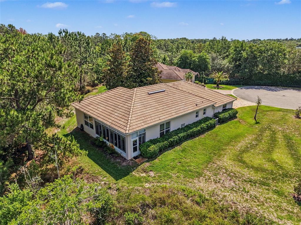 An aerial view shows a single-story house with a tiled roof and a screened-in porch — 8910 JERICHO ROAD, WEEKI WACHEE, FL