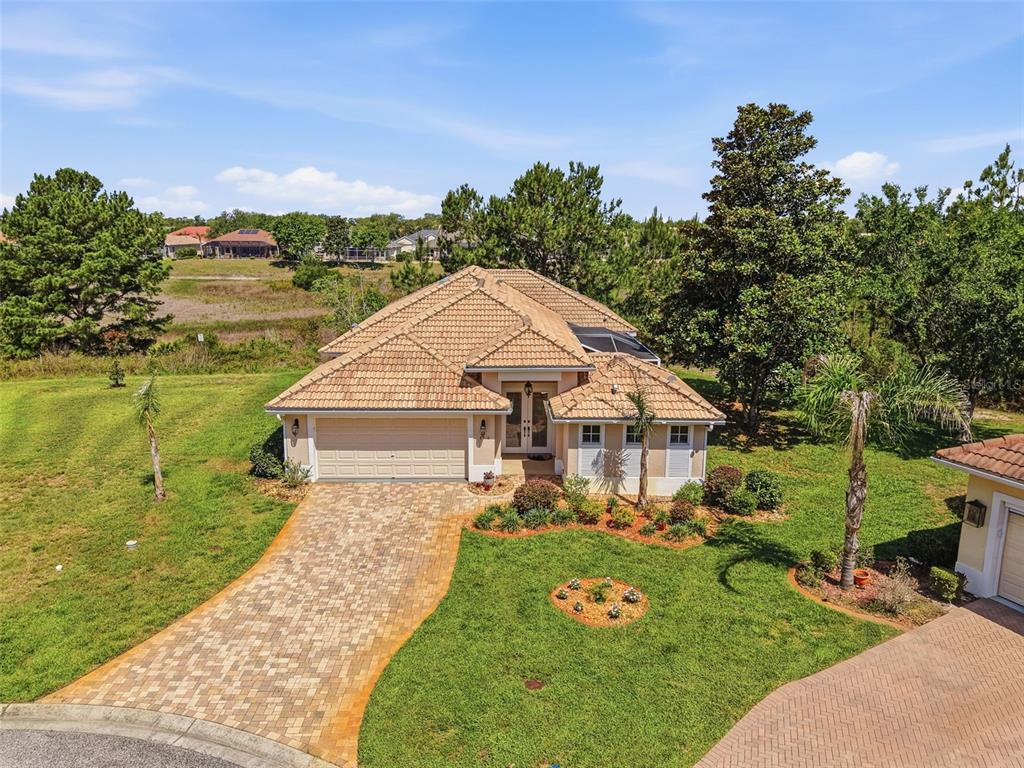An aerial view of a single-story house with a tiled roof and paver driveway — 8910 JERICHO ROAD, WEEKI WACHEE, FL
