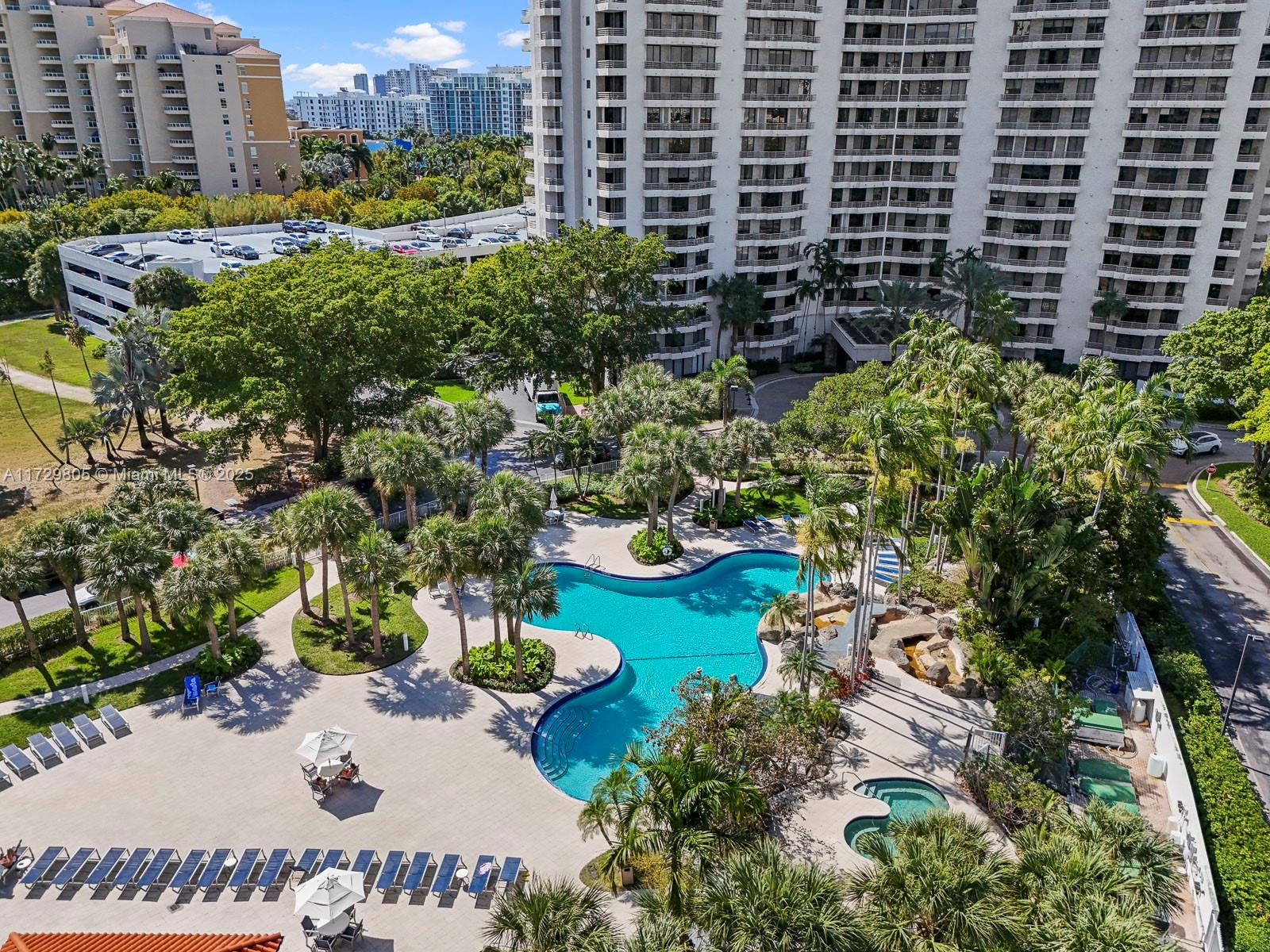 An aerial view shows a swimming pool with a hot tub surrounded by palm trees — 3300 NE 192nd St # 603, Aventura FL 33180, AVENTURA, FL