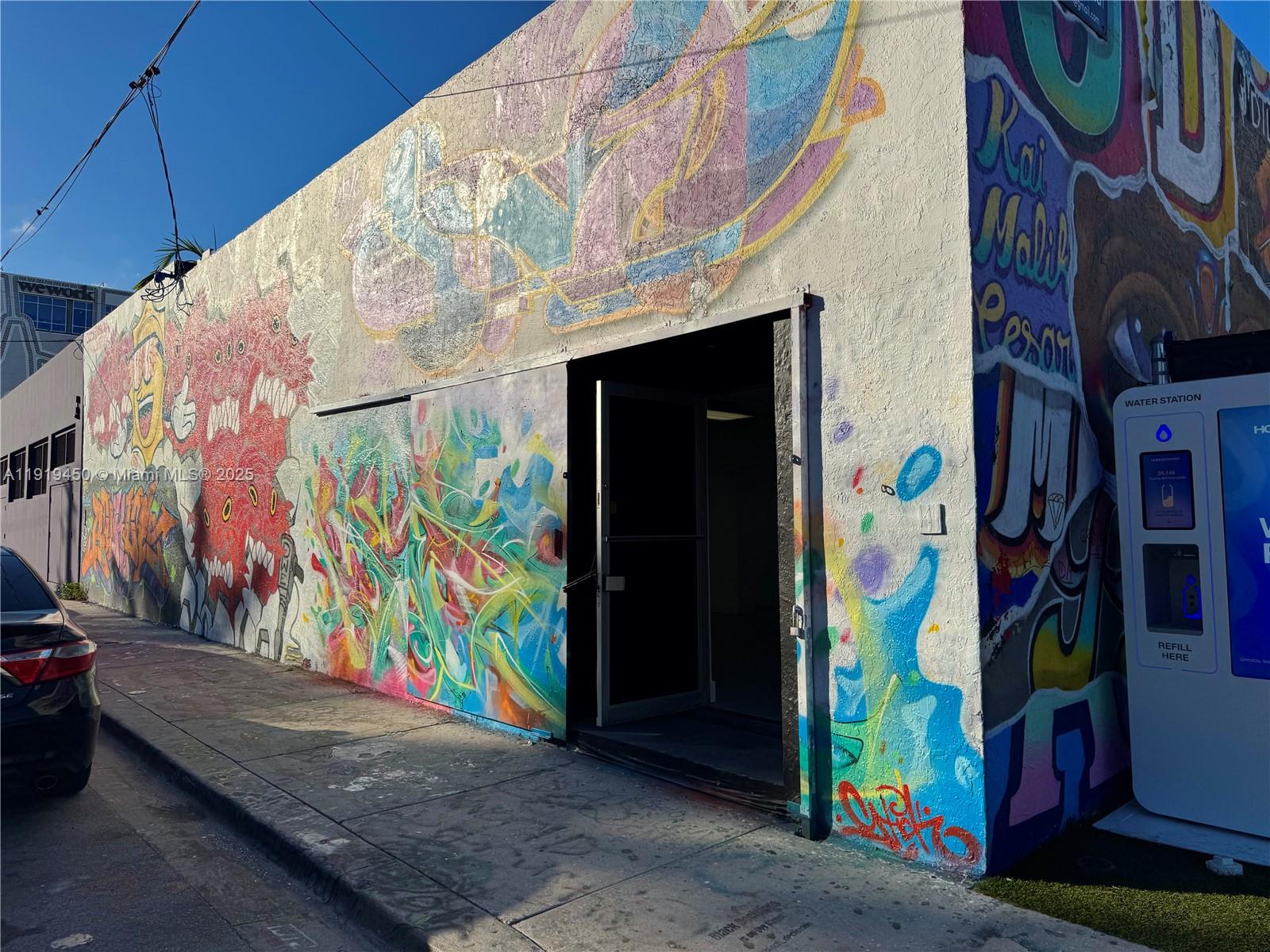 A street-level view of a building exterior covered in vibrant, colorful graffiti murals — 239 NW 26th St, Miami FL 33127, MIAMI, FL