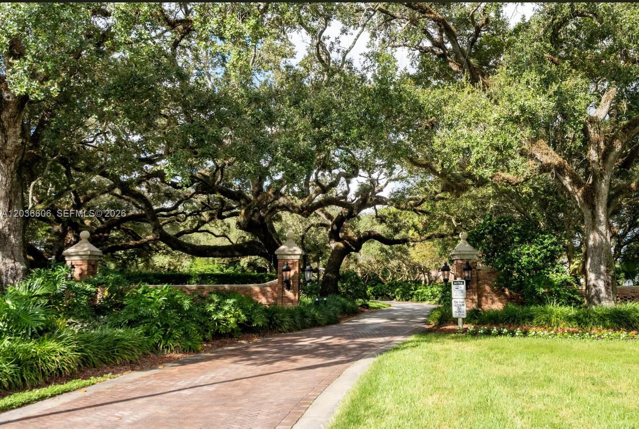 A two-story light blue house with a landscaped front yard and mature trees — 8815 Woodside Ct, Davie FL 33328, DAVIE, FL