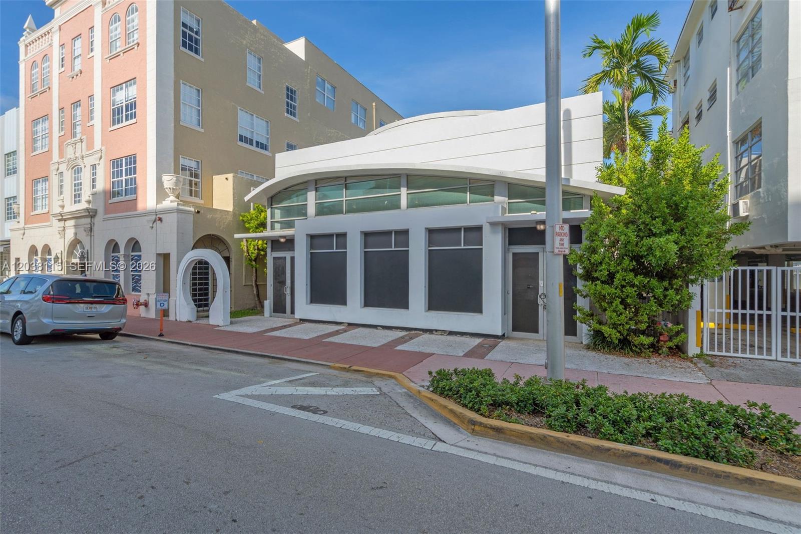 A modern, single-story white commercial building sits between two taller apartment buildings on a street — 721 Collins Ave, Miami Beach FL 33139, MIAMI BEACH, FL