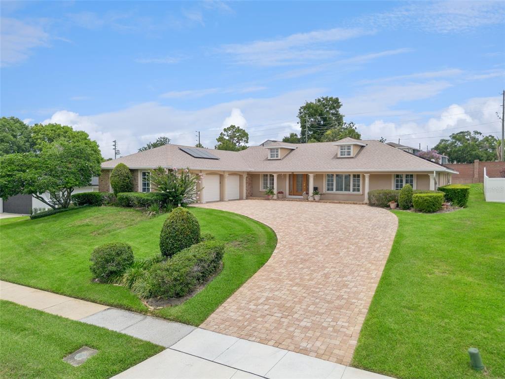 A single-story house with a brick driveway, tan siding, and a large front lawn — 220 ROLLINGWOOD TRAIL, ALTAMONTE SPRINGS, FL