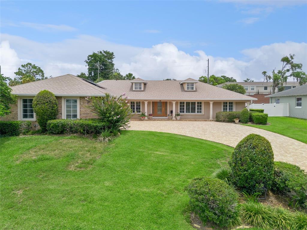 A single-story ranch-style house features a brick facade, a paved driveway, and a large lawn — 220 ROLLINGWOOD TRAIL, ALTAMONTE SPRINGS, FL