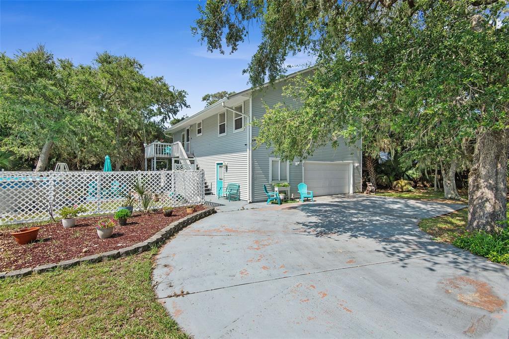 A two-story house with light gray siding, a garage, and a fenced pool area — 26 BEACHSIDE DRIVE, PALM COAST, FL