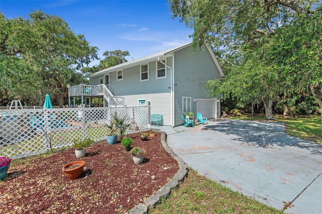 A two-story house with light gray siding, a deck, a pool, and a concrete driveway — 26 BEACHSIDE DRIVE, PALM COAST, FL