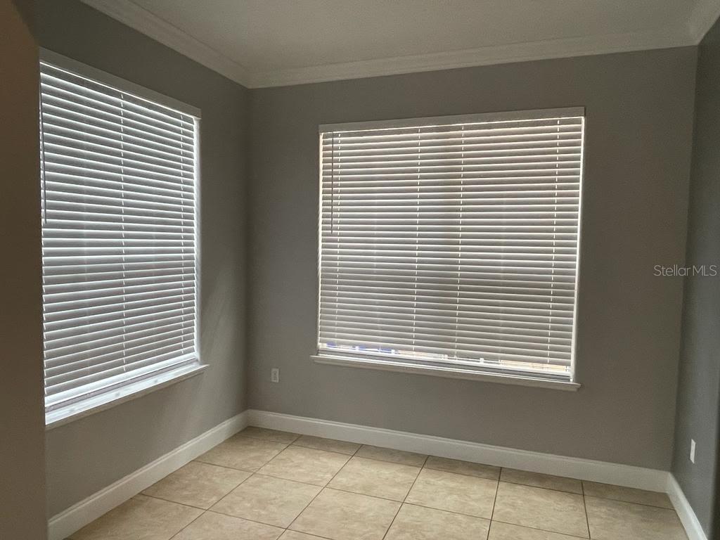 A room with light gray walls, tile flooring, and two windows covered by white blinds — 1604 EAGLE FEATHER DRIVE, KISSIMMEE, FL