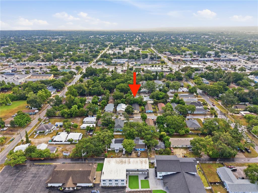 An aerial view shows a residential neighborhood with a red arrow pointing to a house — 1734 CRAWFORD AVENUE, CLEARWATER, FL