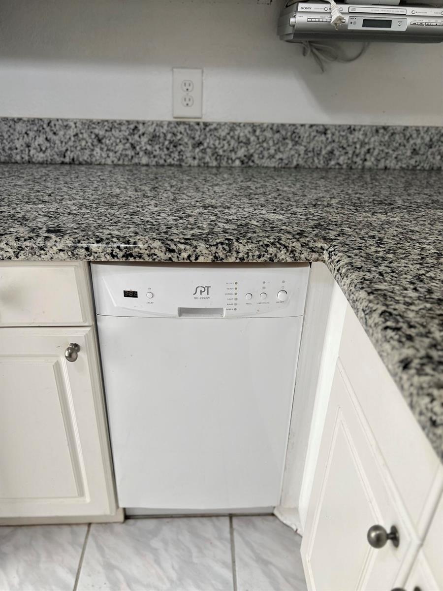 A white SPT dishwasher is installed under a granite countertop in a kitchen — 2161 NE 1st Court # 102, Boynton Beach FL 33435, BOYNTON BEACH, FL
