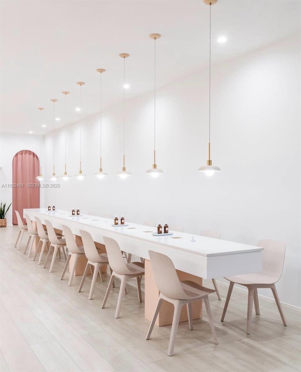 A long white table with chairs is illuminated by a row of pendant lights — 240-290 N Federal Highway, Fort Lauderdale FL 33301, FORT LAUDERDALE, FL