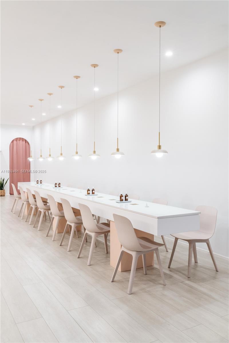 A long white table with chairs is illuminated by a row of modern pendant lights — 240-290 N Federal Highway, Fort Lauderdale FL 33301, FORT LAUDERDALE, FL