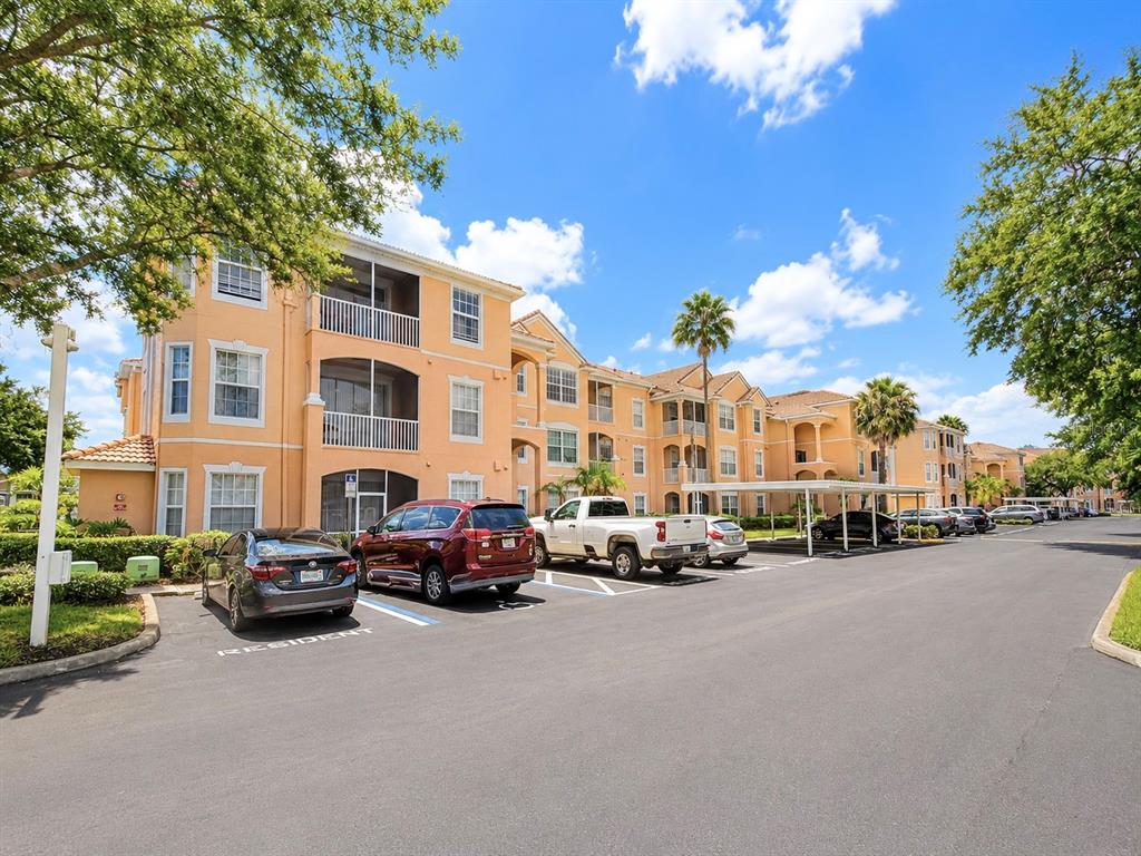 An exterior view of a multi-story apartment complex with a parking lot in front — 13524 TURTLE MARSH LOOP UNIT 634, ORLANDO, FL