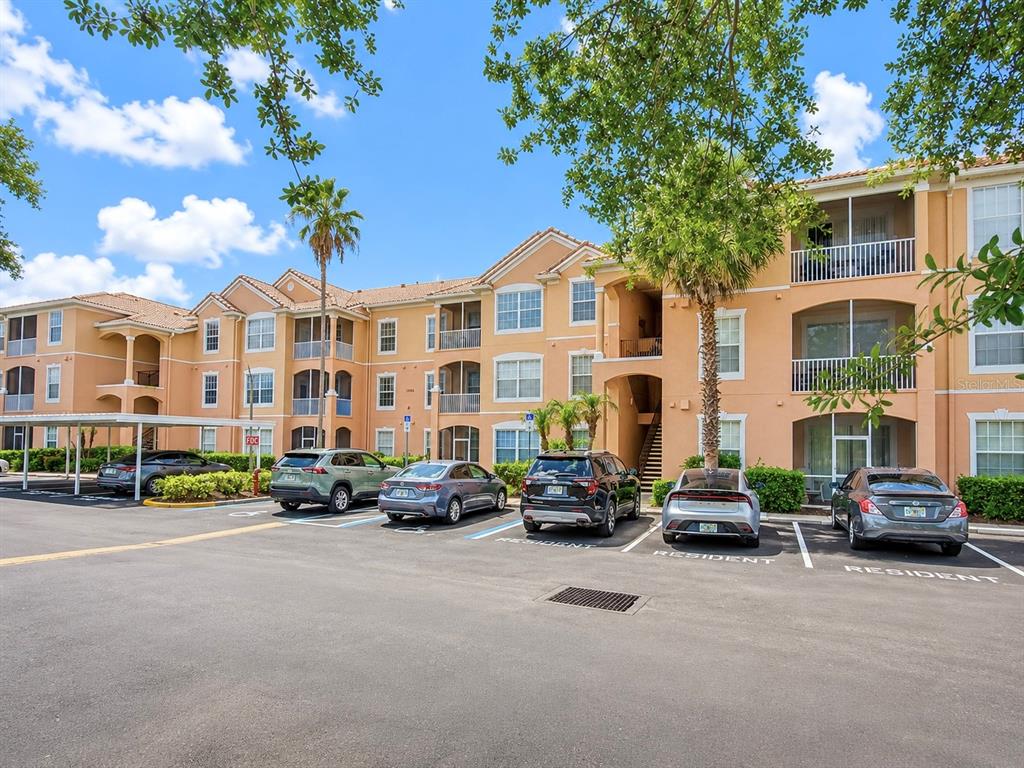A multi-story apartment building with a parking lot in the foreground — 13524 TURTLE MARSH LOOP UNIT 634, ORLANDO, FL
